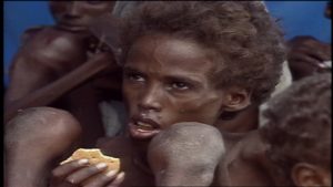 Starving Somali boy with ifesaving food aid biscuit